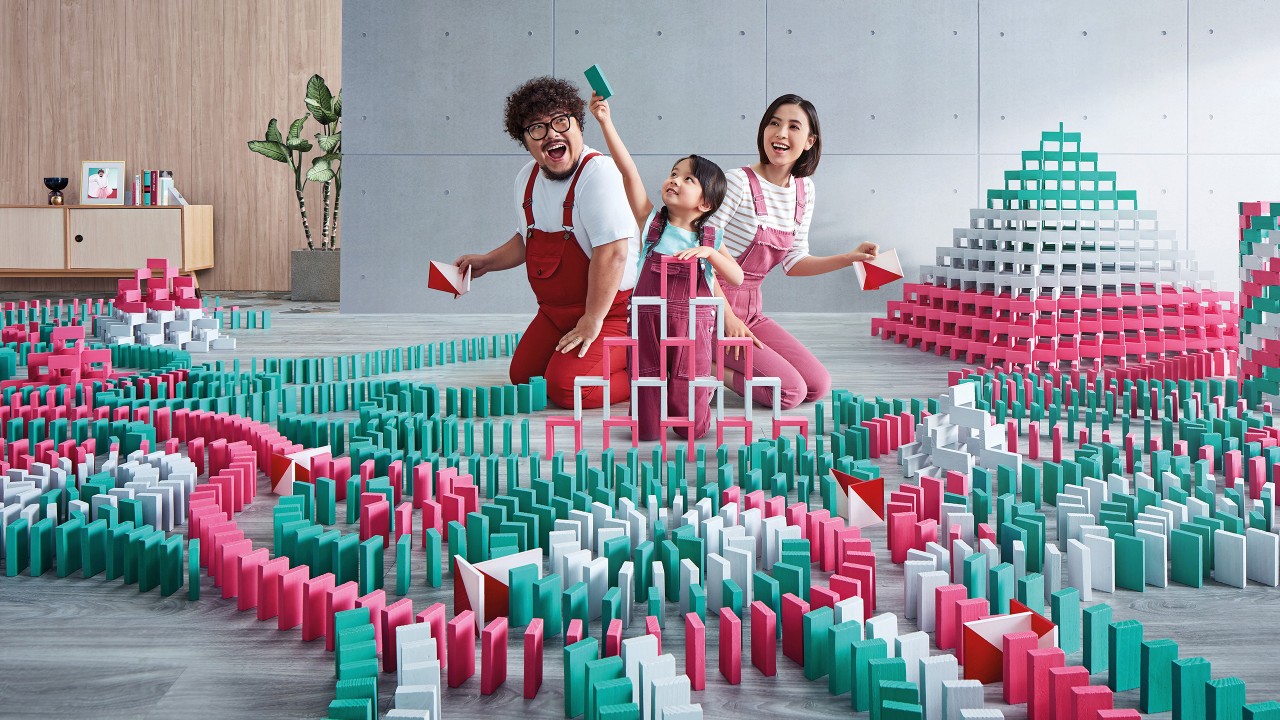 Family are playing doguno;image used for HSBC Health Goal Insurance Plan.