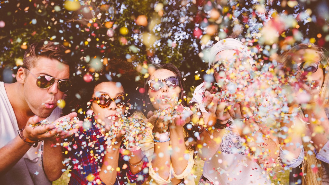 Hipsters blowing confetti; image used for earning online spending rewards.