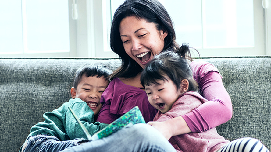 Mother reading to kids on sofa; image used for HSBC Term Life Insurance.