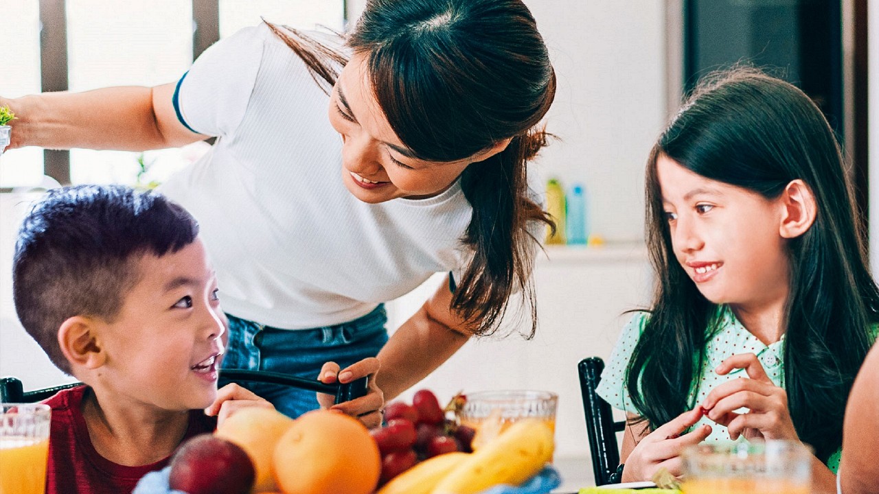 母親和兒子及女兒在吃水果；圖片使用於滙豐財富管理家庭保障頁面。