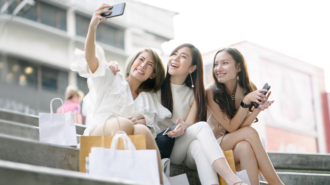 Three girls are taking selfie on the staircase; image used for HSBC Spending Instalment Plan promotional Page.