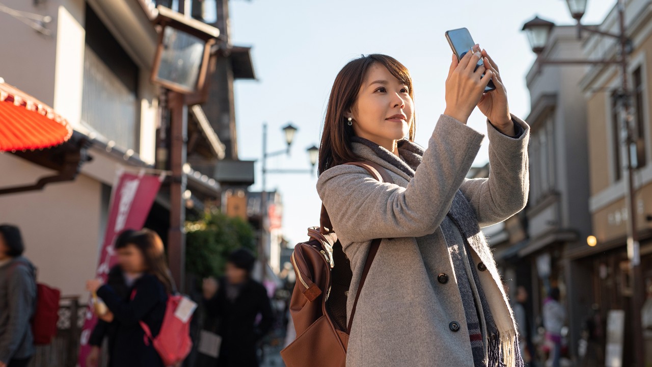 A lady is taking photo by mobile phone; image used for HSBC Cash Instalment Plan Article.