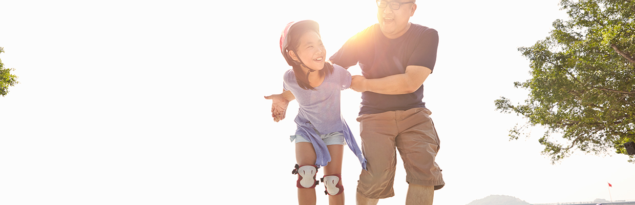 Father is helping little daughter while roller skating; image used for HSBC Help and Support.