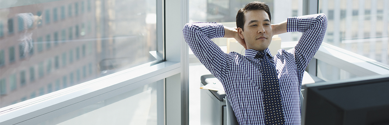 A businessman relaxing at desk in office; image used in HSBC Foreign Currency Time Deposit page.