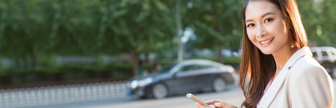 A woman is using smart phone; image used in HSBC Hong Kong Dollar Savings Account page.