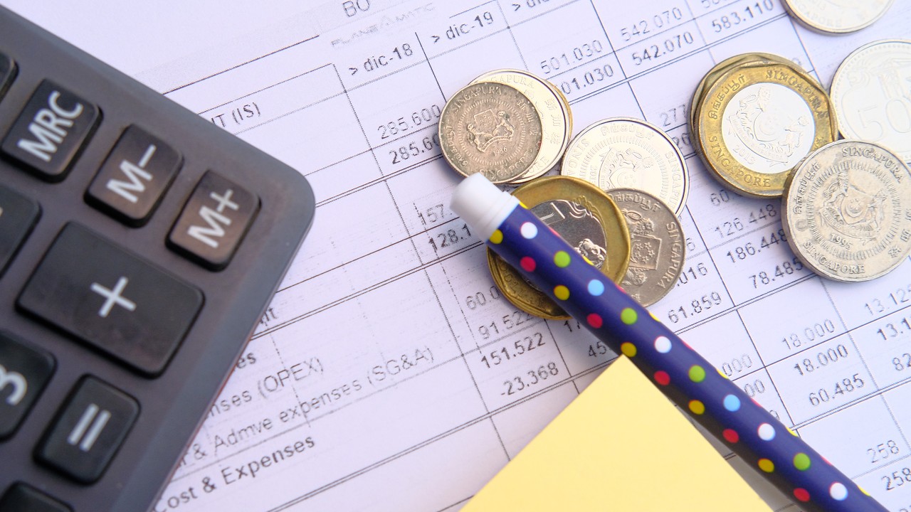 鉛筆和硬幣放在財務報告上; 圖片使用於房地產頁面的圖像
