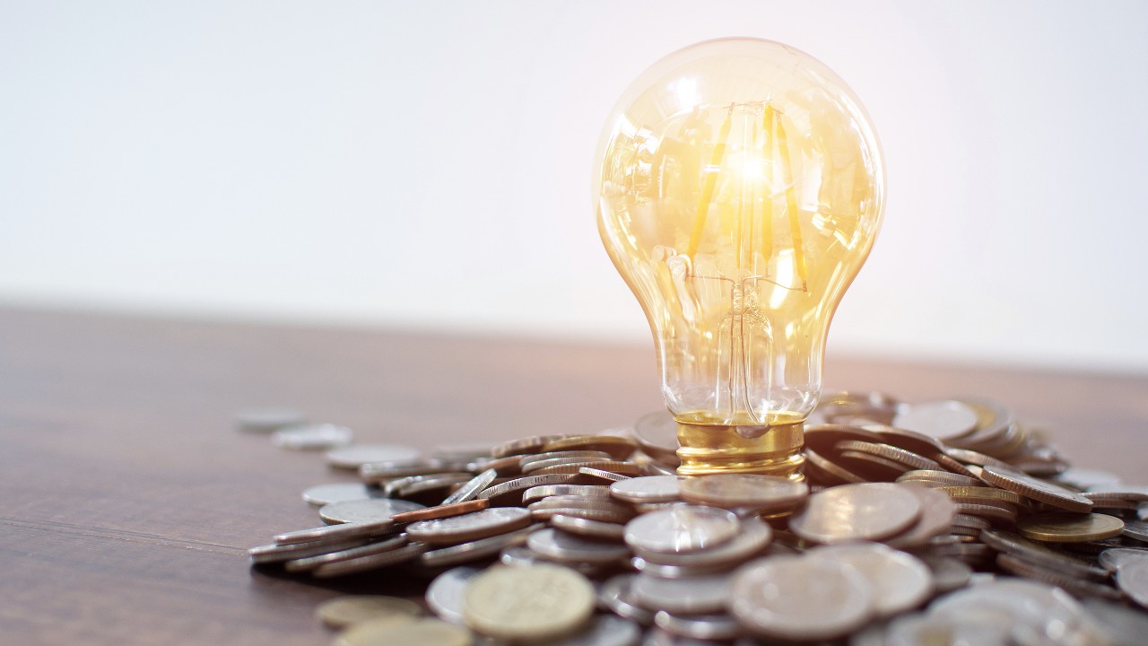 A light bulb is placed on coins; image used for margin financing page