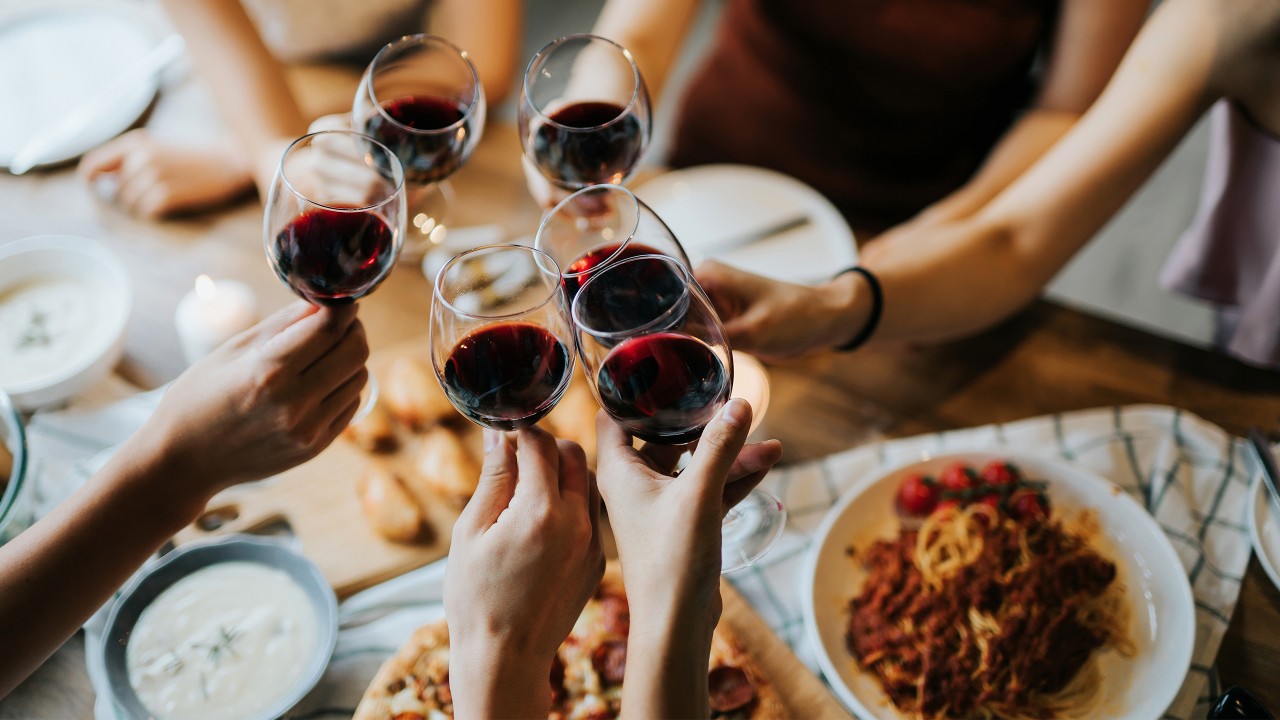 Friends are enjoying red wine with food; image used for HSBC Credit Card.