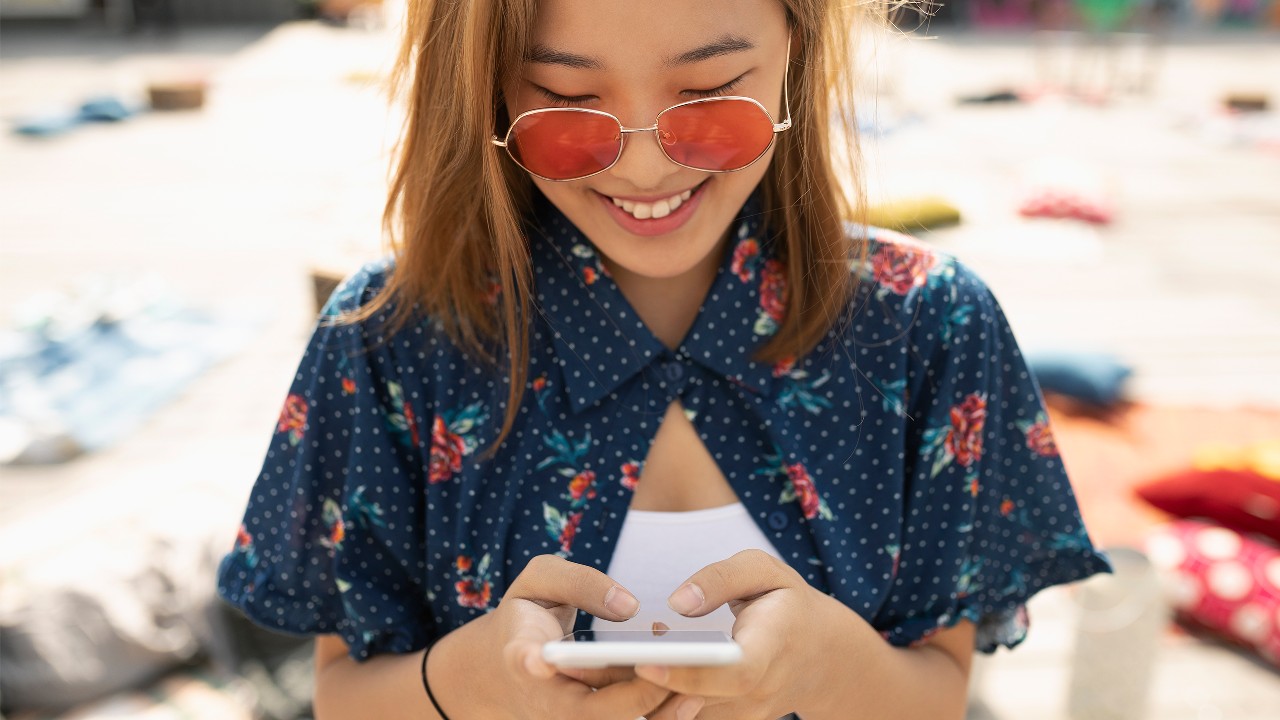 女人看着她的电话；图片使用于汇丰最红奖赏计划。