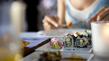 一位女士正在吃日本料理;圖片使用於滙豐最紅優惠網頁面。