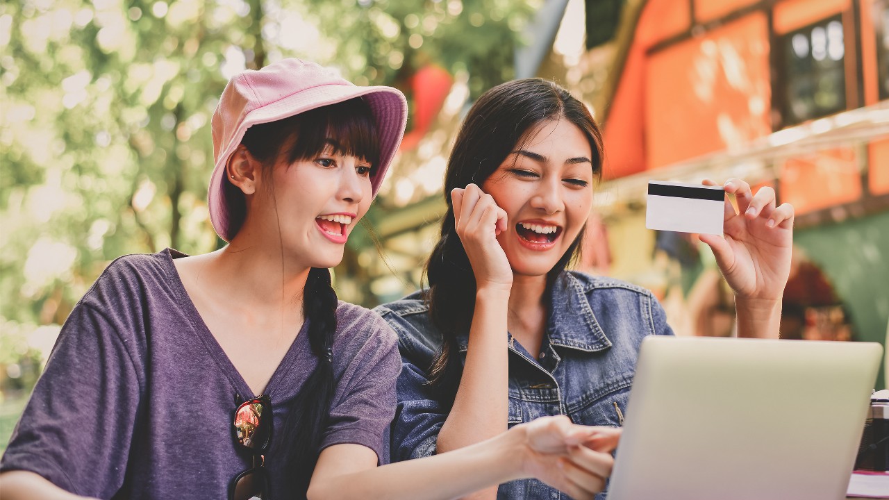 女孩正在享受網上購物； 圖片使用於用滙豐Red信用卡賺盡網上簽賬優惠的頁面。