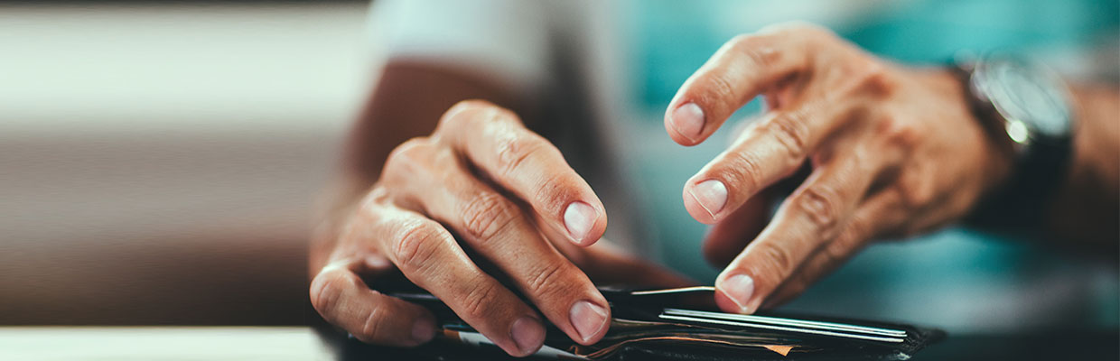 A man is placing his card to wallet; image used for HSBC Hong Kong customer liability.