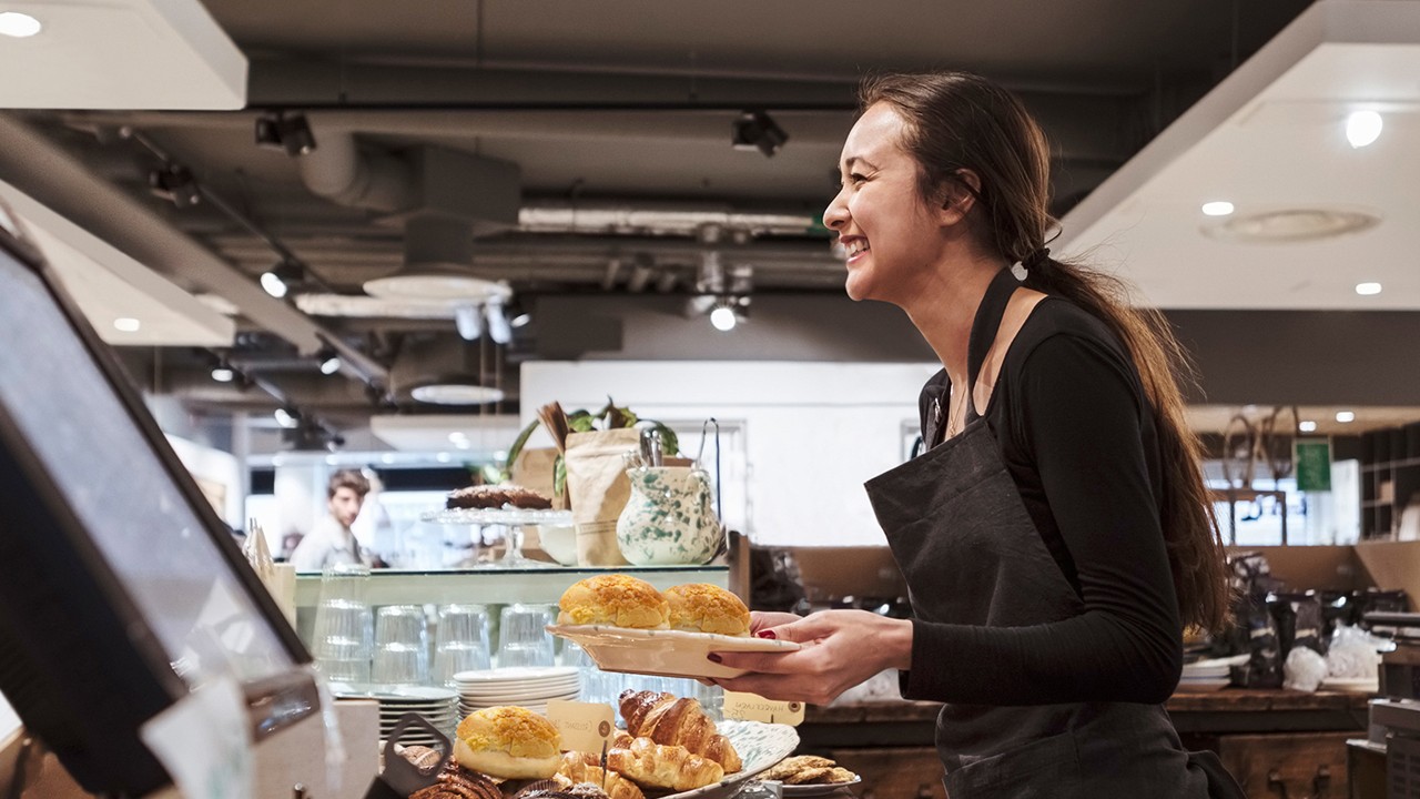 A waitress is providing food in the bakery; image used for CMB website.