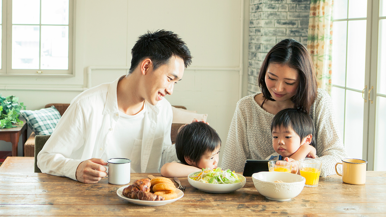 一家人在餐桌上吃飯;圖片使用於樂安居供樓保障計劃頁面。
