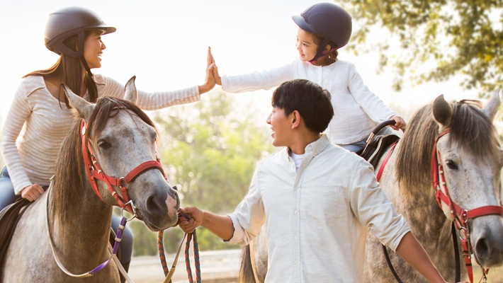 一家人在一起騎馬；圖片使用於滙豐聚富入息延期年金計劃頁面。