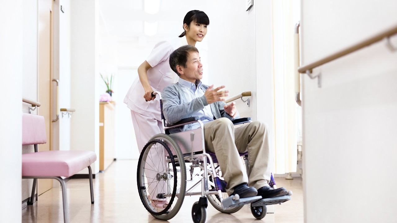 護士與坐在輪椅上的男士；圖片使用於滙豐「意外萬全保」頁面。