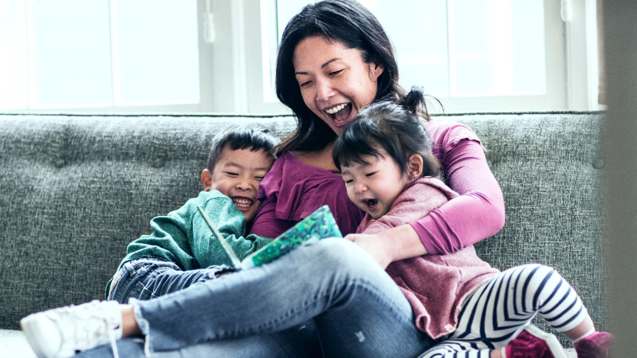 Mother reading to kids on sofa; image used for HSBC Term Life Insurance.