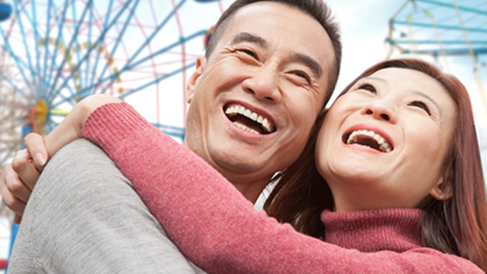 A couple is hugging under the ferris wheel; image used for EarlyIncome Annuity Plan.