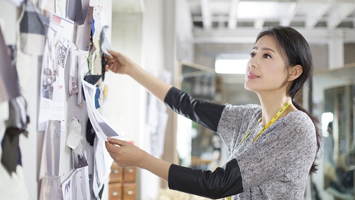 A lady tailor is looking at her design board; image used for HSBC Wealth Management Family Mapping your journey page.