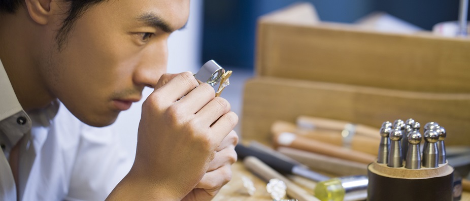 A man is checking on something with a magnifier; image used for HSBC Wealth Management page.