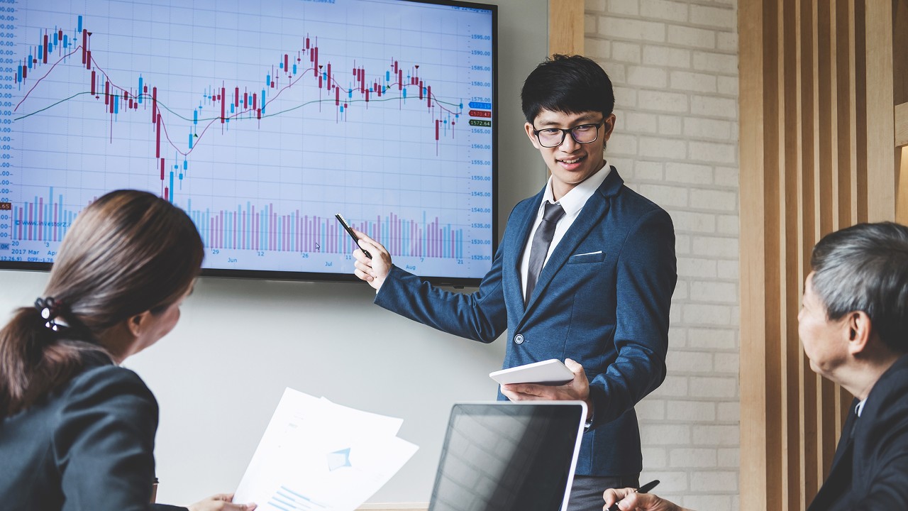 A working group discussing about a stocks chart