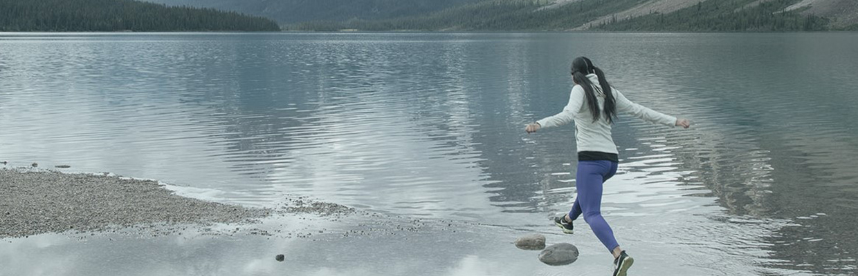 Woman playing stone jumping in a beach;image used for HSBC Jade SupportEntreprenHER