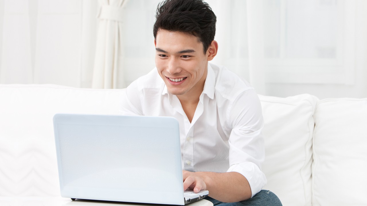 A man is using his laptop; image used for Online and banking security.