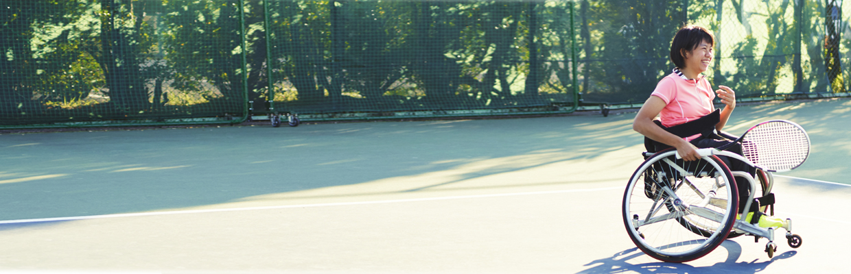 Woman playing tennis in wheelchair ; image used for Accessibility for people with disabilities .