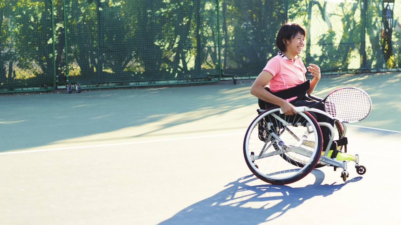 Woman playing tennis in wheelchair; image used for Accessibility for people with disabilities.