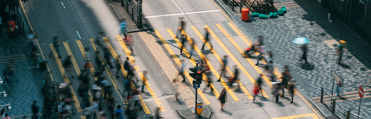 People and taxi crossing busy crossroads in Tsim Sha Tsui; image used for Services for our Hong Kong Community.