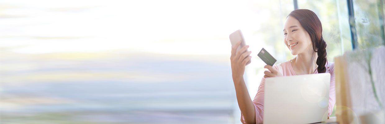 Woman shopping online with smartphone and credit card; image used for HSBC Credit Cards.