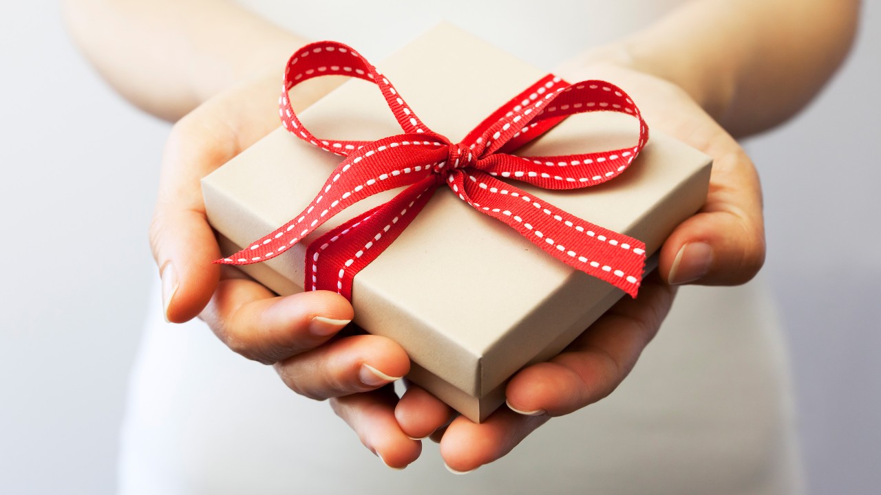 A person holding a gift in both hands.