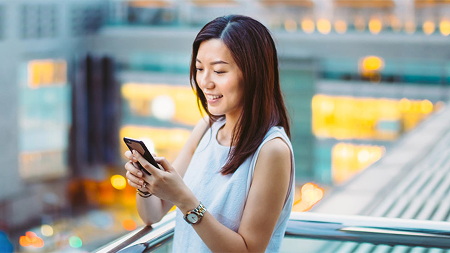 Woman looking at phone; image used for HSBC Red Hot Rewards.