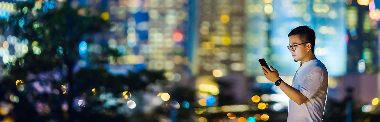 A man is checking information on his smart phone; image used for HSBC cyber security index.