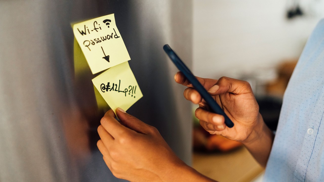 A man is taking photo for the sticker on the board; image used for HSBC cyber security index.