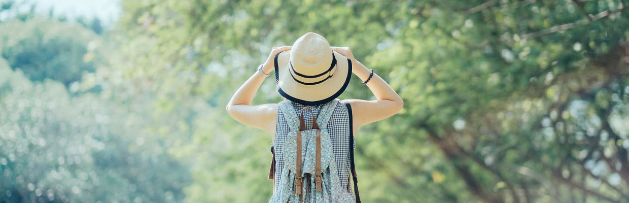 Woman standing against green nature; image used for HSBC Insurance Article.