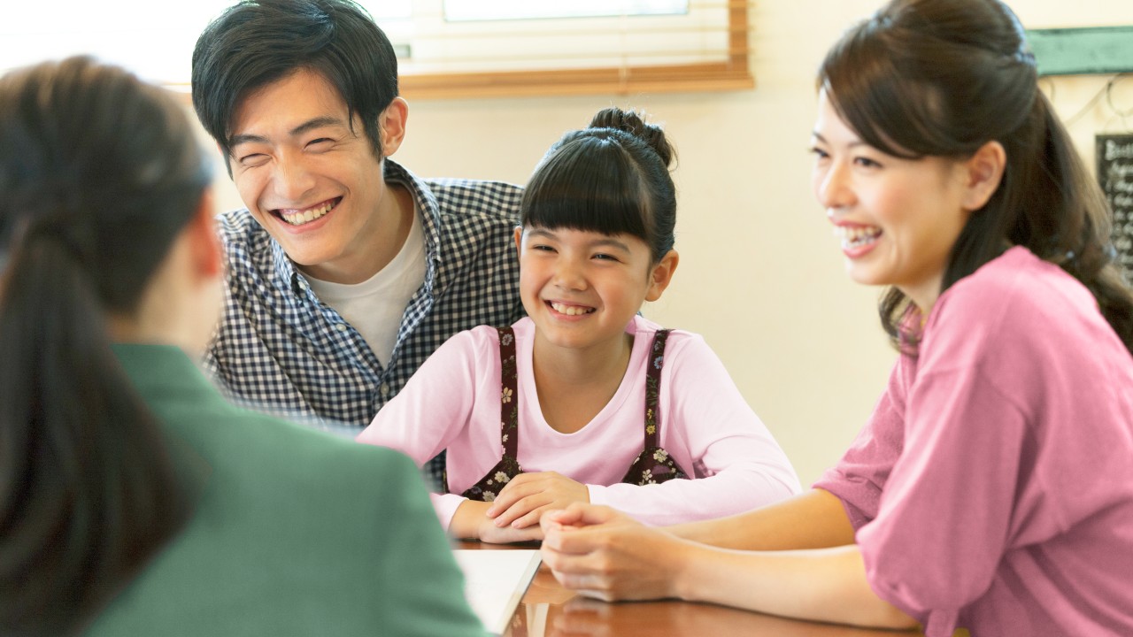 Family listening to adult; image used for About HSBC LIFE "Diverse product portfolio".