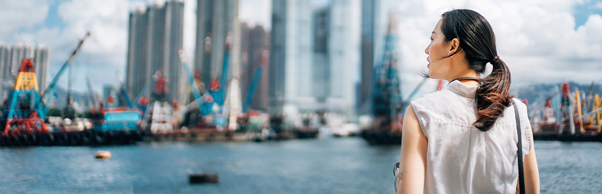 女士正在俯瞰城市景观；图片使用于香港本地银行服务。