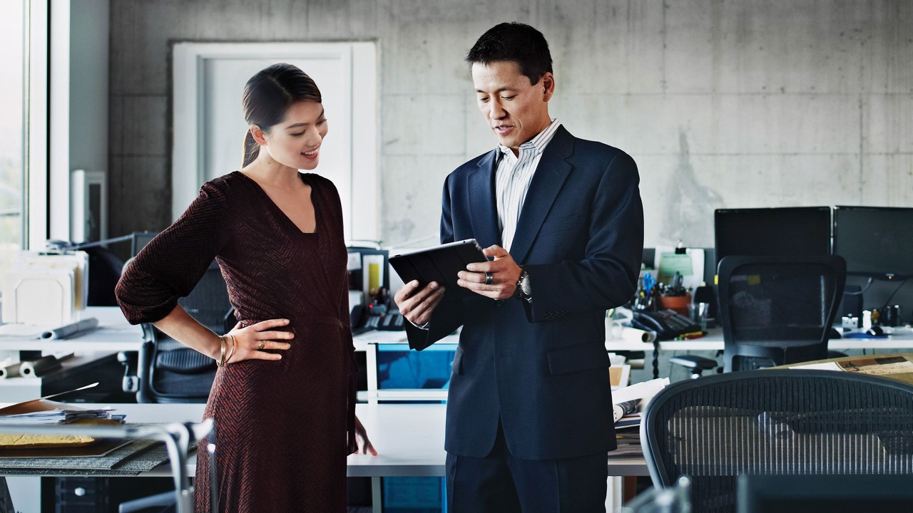 Coworkers are looking at digital tablet; image used for Commercial banking.