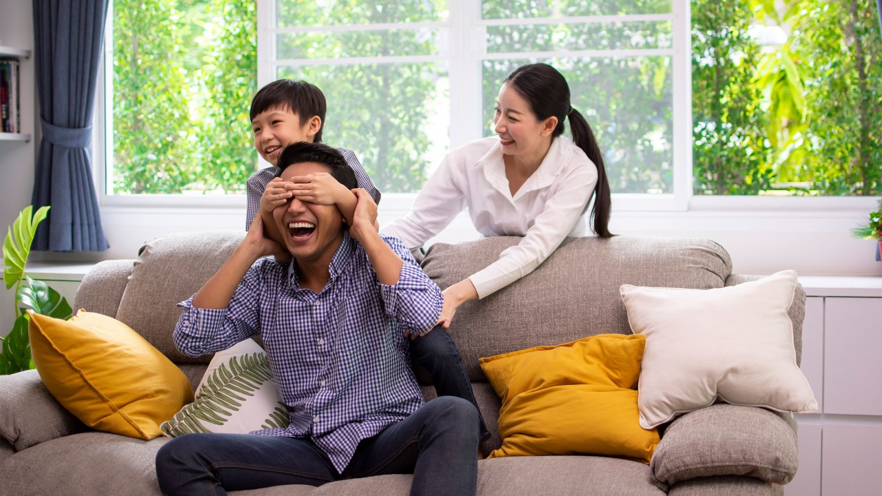 Happy family playing together in the living room; image used for Personal banking.