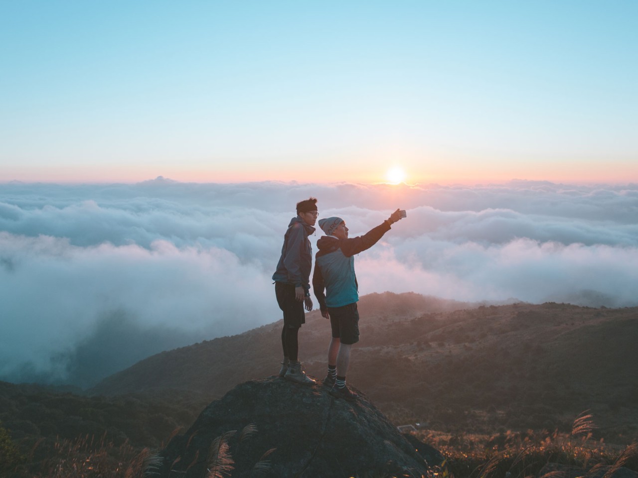 Two young men are standing at the peak