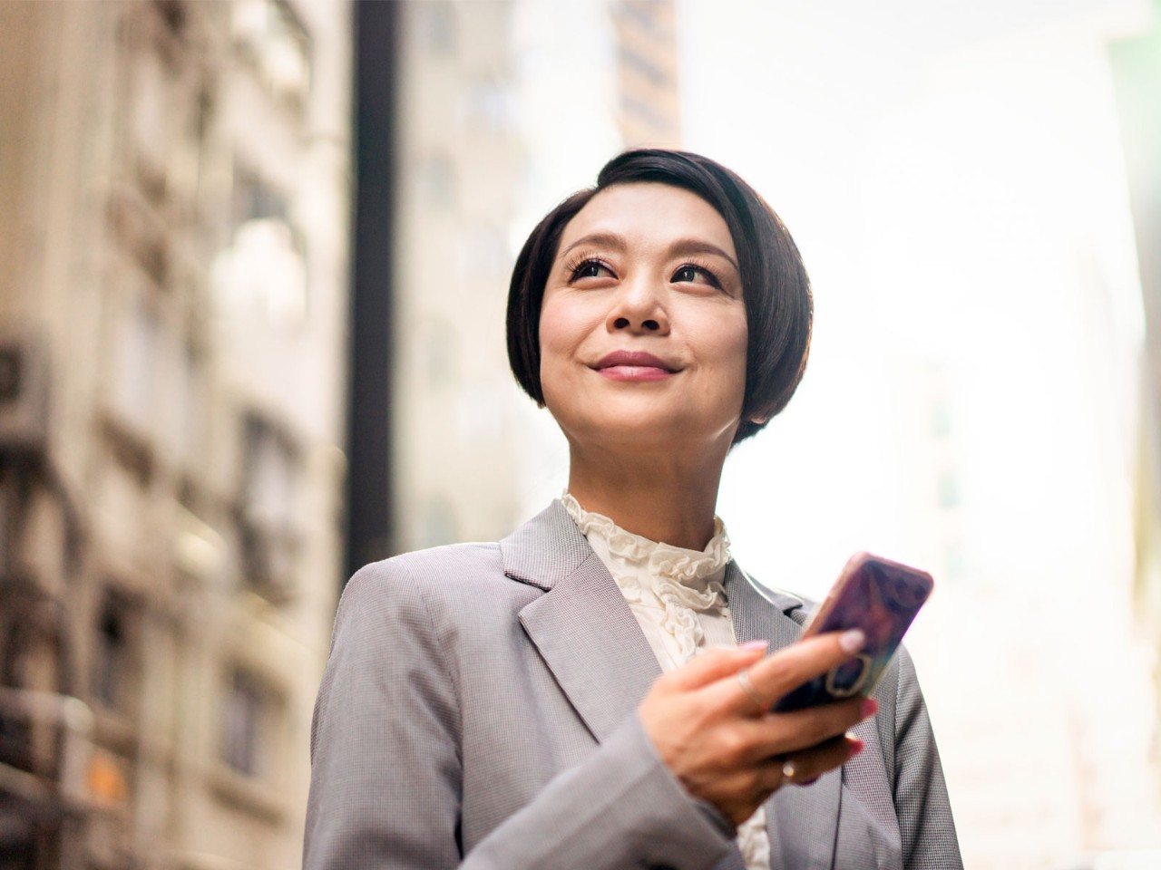 A businesswoman is confidently looking up at the sky