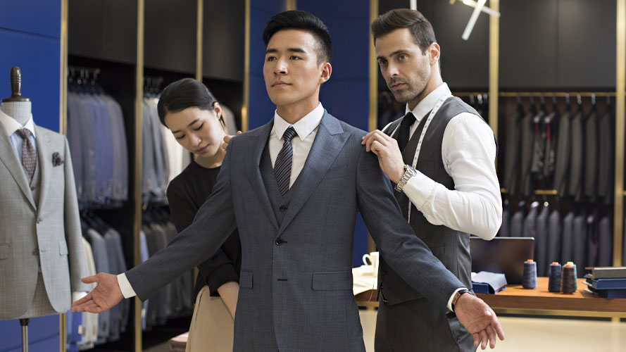 A tailor measuing a man's body for suit; image used for HSBC Insurance Article.