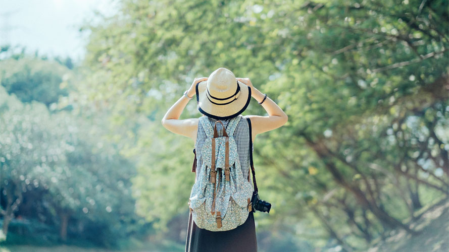 Woman standing against green nature; image used for HSBC Insurance Article.