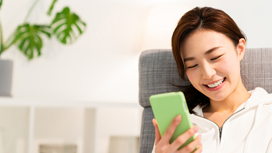 Woman looking at mobile phone; image used for HSBC FlexInvest