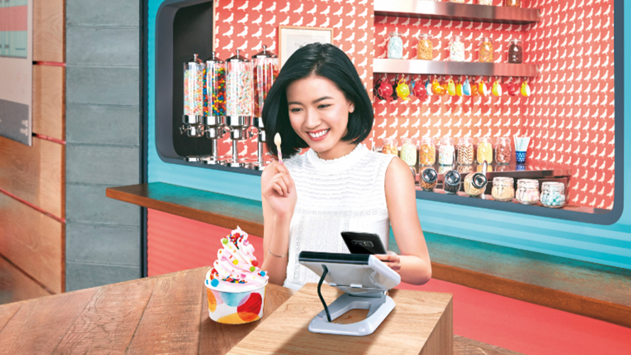 Woman paying for her ice cream using mobile payment; image used for HSBC RewardCash rebate offer